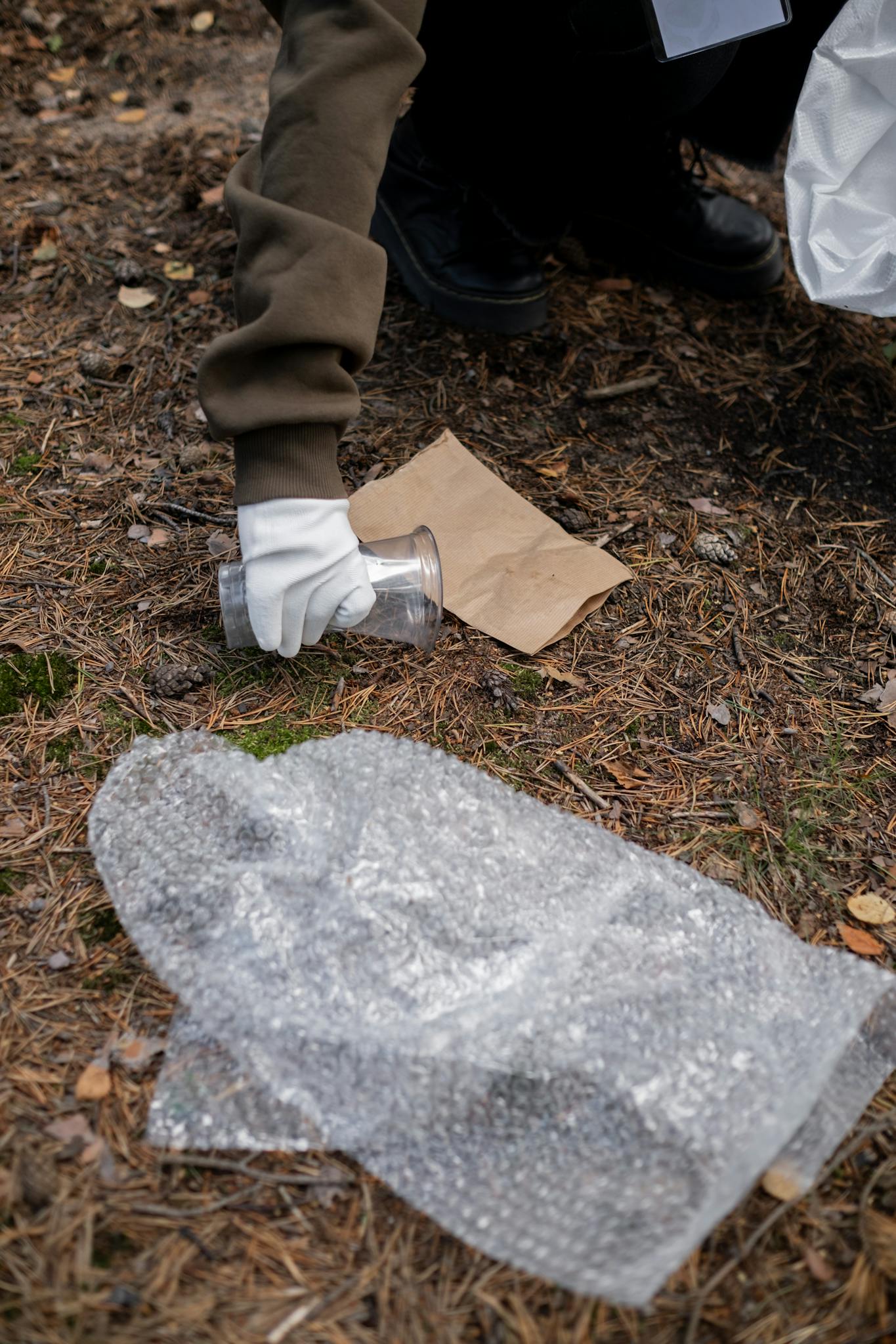 A volunteer picking up trash outdoors, promoting environmental cleanliness.